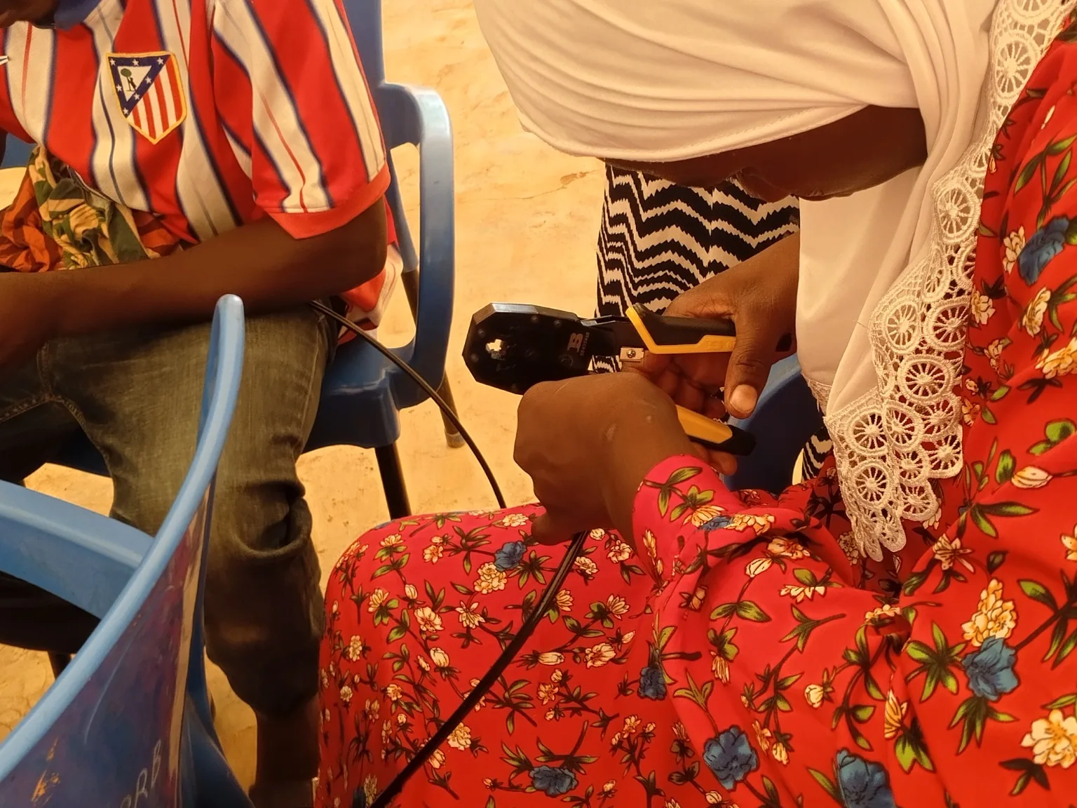 Young participant learning Ethernet cable termination during an AFRISTEMI networking training